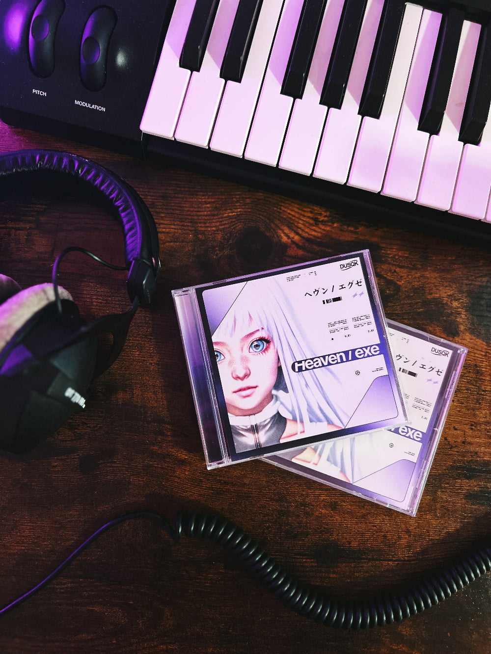 Two Heaven/EXE CDs with jewel case, with keyboard and headphones in background