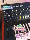 Music synthesizer with Dusqk branding on stickers and display