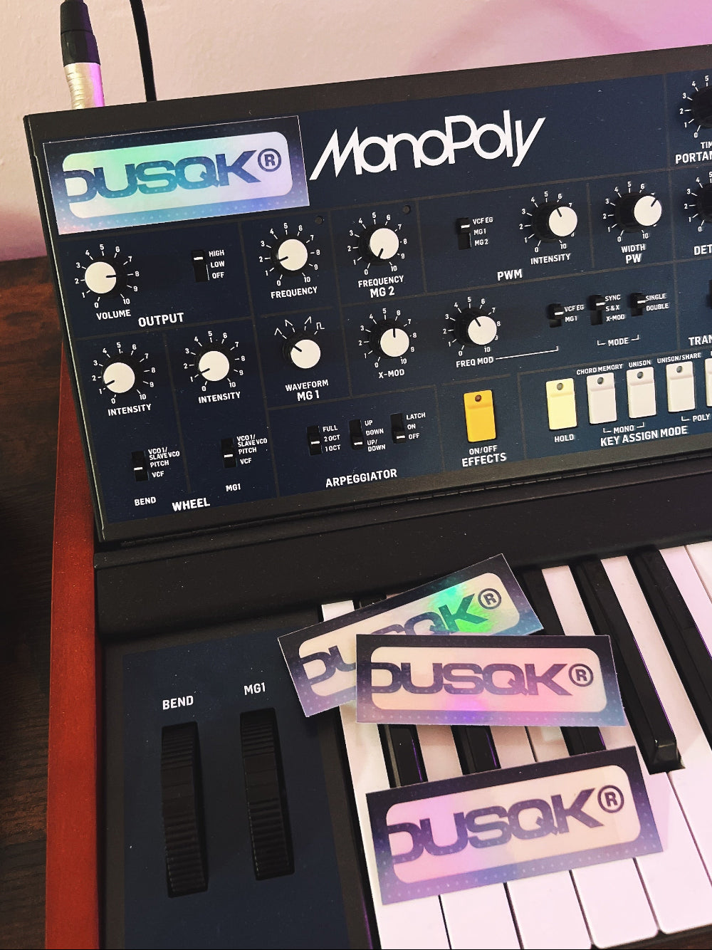 Music synthesizer with Dusqk branding on stickers and display