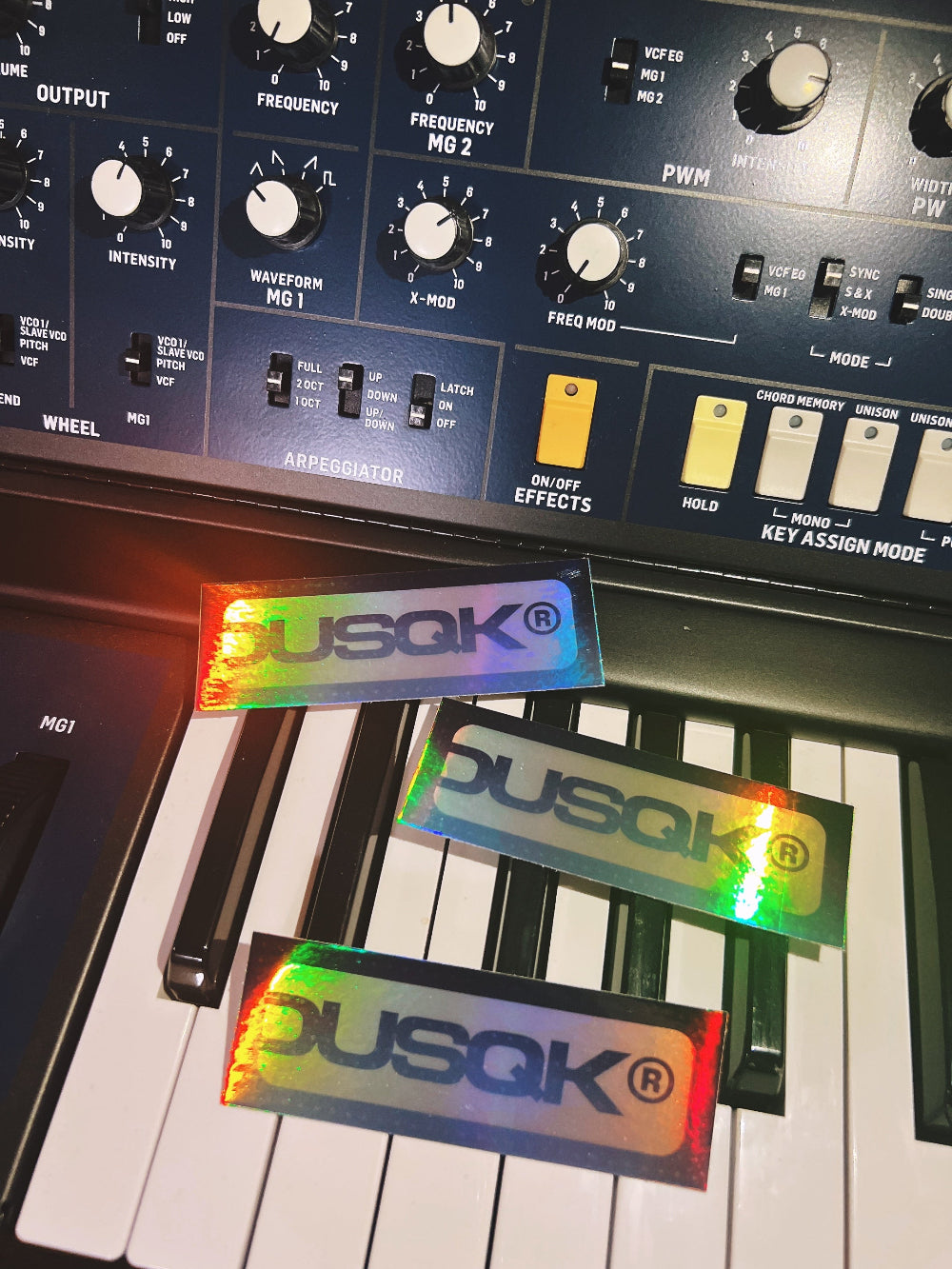 Music synthesizer with Dusqk branding on stickers and display