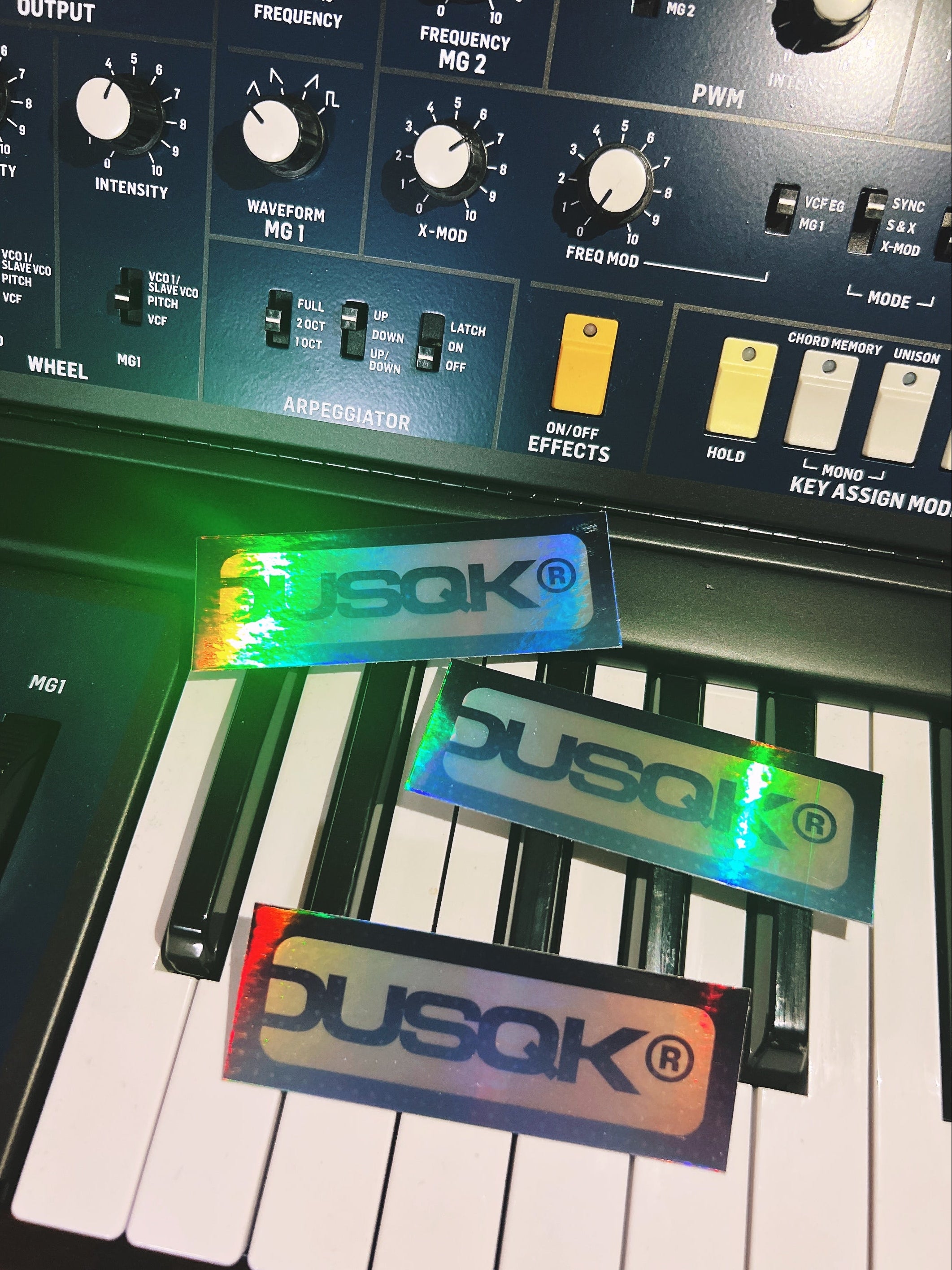Music synthesizer with Dusqk branding on stickers and display